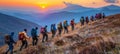 Adventurous group of people hiking together in the mountains at sunset during a summer trek Royalty Free Stock Photo