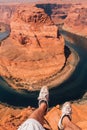 Adventurous hiker sitting on the edge of the cliff in the Horseshoe Bend in Arizona, USA