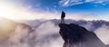 Adventurous Man Hiker standing on top of peak with rocky mountain in background. Royalty Free Stock Photo