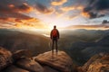 Adventurous Man Hiker Standing on top of a rocky mountain overlooking the dramatic landscape at sunset Royalty Free Stock Photo