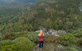 Man standing at the edge of a cliff overlooking the mountains below, aerial drone view Royalty Free Stock Photo