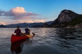 Adventurous people on a canoe are enjoying the Canadian Mountain Landscape