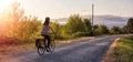 Adventurous White Cacasusian Woman riding a bicycle on a road.