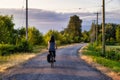 Adventurous White Cacasusian Woman riding a bicycle on a road.