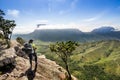 adventurous woman with backpack looking at a beautiful green valley