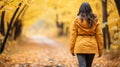 Adventurous woman hiking on picturesque autumn forest trail surrounded by vibrant fall foliage. Royalty Free Stock Photo