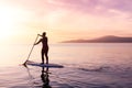 Adventurous girl on a paddle board is paddeling in the Pacific West Coast Ocean Royalty Free Stock Photo