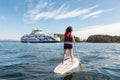 Adventurous woman paddle boarding near BC Ferries Boat in Swartz Bay