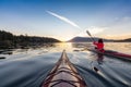 Adventurous Woman on Sea Kayak paddling in the Pacific Ocean. Sunny Summer Sunset