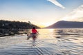 Adventurous Woman on Sea Kayak paddling in the Pacific Ocean. Sunny Summer Sunset