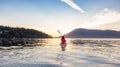 Adventurous Woman on Sea Kayak paddling in the Pacific Ocean. Sunny Summer Sunset