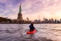 Adventurous Woman Sea Kayaking near the Statue of Liberty