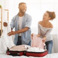 Adventurous young couple packing suitcase at home Royalty Free Stock Photo