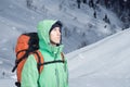 Adventurous young man with backpack standing on mountainside view and looking out. Royalty Free Stock Photo