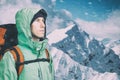 Adventurous young man with backpack standing on mountain top view and looking out. Mountaineering, extreme sport. Royalty Free Stock Photo