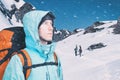 Adventurous young man with backpack standing on mountain top view and looking out. Snowboarders walking uphill for Royalty Free Stock Photo