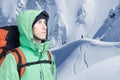 Adventurous young man with backpack standing on mountainside view and looking out. Mountaineering, extreme sport. Royalty Free Stock Photo