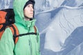 Adventurous young man with backpack standing on mountainside view and looking out. Mountaineering, extreme sport. Royalty Free Stock Photo