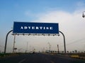 Advertise - Blank blue sign on a large pole against blue sky