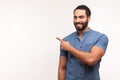 Advertise here! Positive bearded man pointing finger away paying your attention at empty space for advertisement, looking at Royalty Free Stock Photo
