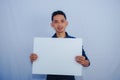 Advertisement Concept. Portrait of asian man holding empty blank board isolated on white studio background. Royalty Free Stock Photo