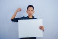 Advertisement Concept. Portrait of asian man holding empty blank board isolated on white studio background. Royalty Free Stock Photo