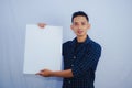 Advertisement Concept. Portrait of asian man holding empty blank board isolated on white studio background. Royalty Free Stock Photo