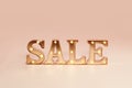 Advertisement Sale illuminated metal letters at pastel background