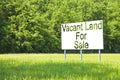 Advertising billboard immersed in a rural scene with Vacant Land for Sale written on it - image with copy space Royalty Free Stock Photo