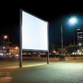 Advertising poster on the street at night. White blank city billboard for mockup standing outdoors, city lights Royalty Free Stock Photo