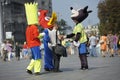 Advertising promoters in animal costumes stand on a street trying to convince young man to buy something