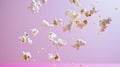 Advertising shot of falling from above peaces of popcorn, static up shot on neutral pink background