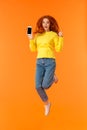 Advertising, technology and holidays concept. Vertical full-length shot cheerful gorgeous ginger girl, redhead woman