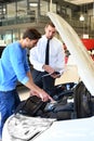 Advice in the car dealership - seller and young man selling a new car Royalty Free Stock Photo