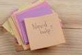 Advice concept - Sticker with the words "need help" on wooden background. Concept of asking for help Royalty Free Stock Photo