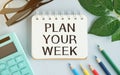 Advice to Plan Your Week in red text on a yellow sticky note posted on the page of a calendar Royalty Free Stock Photo