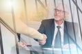 Adviser shaking hand with client after signing a contract, light effect; multiple exposure Royalty Free Stock Photo