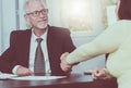 Adviser shaking hand with client after signing a contract, light effect Royalty Free Stock Photo