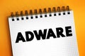 Adware - unwanted software designed to throw advertisements up on your screen, text concept on notepad Royalty Free Stock Photo
