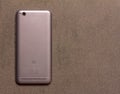 Chinese smartphone Xiaomi Redmi 5A silver back side close up view from above on grey background with copy space