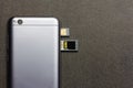 Chinese smartphone Xiaomi Redmi 5A silver with open slots for nano SIM cards, micro SD drive back side close up top view on grey b