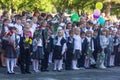 First-graders with bouquets of flowers in their hands and high school students on the day of knowledge on September 1 in the schoo