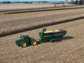 Aeiral view of a John Deere 9420R tractor pulling a Brent 2096 grain cart loaded with corn at harvest time