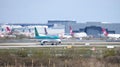 An Aer Lingus Airbus A320-214 moves towards the runway at Gatwick Airport, passing in front of some of the Virgin Atlantic fleet