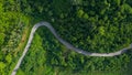 Aerial above view green mountain forest in the rain season and curved road on the hill connecting countryside Royalty Free Stock Photo