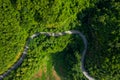 Aerial above view green mountain forest in the rain season and curved road on the hill connecting countryside Royalty Free Stock Photo