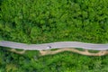 Aerial above view green mountain forest in the rain season and curved road on the hill connecting countryside Royalty Free Stock Photo