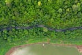 Aerial above view green mountain forest and river in the rain season and curved road on the hill connecting countryside Royalty Free Stock Photo