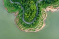 Aerial above view green mountain forest and river in the rain season and curved road on the hill connecting countryside Royalty Free Stock Photo