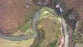 Aerial above view of a wild mountain river meander and a gigantic cave entrance. Unguru Mare cave, Suncuius, Romania